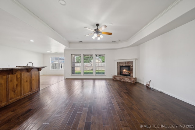 12523 S Cedar Pl, Jenks, OK 74037 - unfurnished living room featuring a tray ceiling, ceiling fan, dark wood finished floors, a fireplace, and recessed lighting
