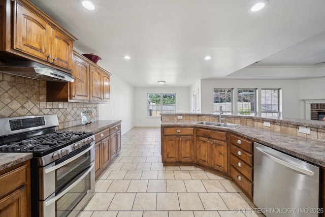 12523 S Cedar Pl, Jenks, OK 74037 - kitchen featuring stainless steel appliances, under cabinet range hood, decorative backsplash, recessed lighting, and brown cabinetry