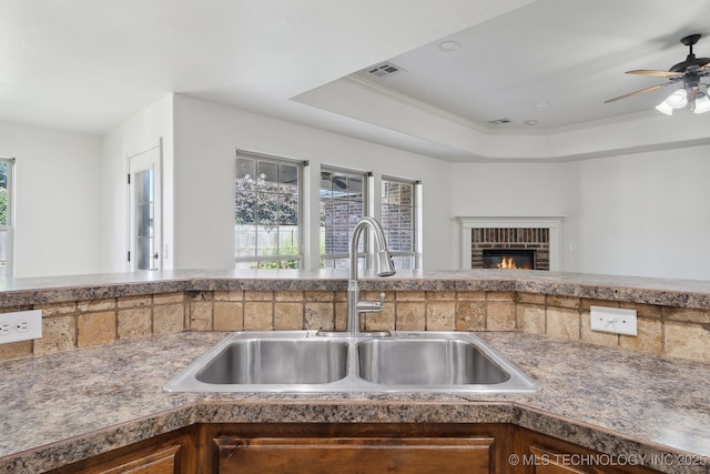 12523 S Cedar Pl, Jenks, OK 74037 - kitchen featuring ceiling fan, a fireplace, and a raised ceiling