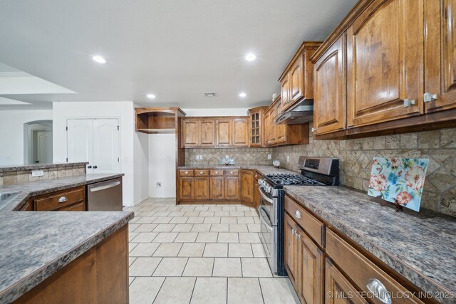 12523 S Cedar Pl, Jenks, OK 74037 - kitchen with stainless steel appliances, brown cabinetry, under cabinet range hood, tasteful backsplash, and light tile patterned flooring