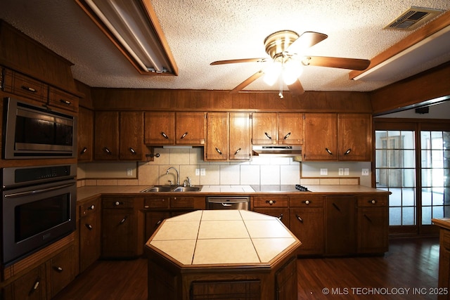 17079 S 125th St, Webbers Falls, OK 74470 - kitchen with stainless steel appliances, a sink, tile counters, ceiling fan, and dark wood finished floors