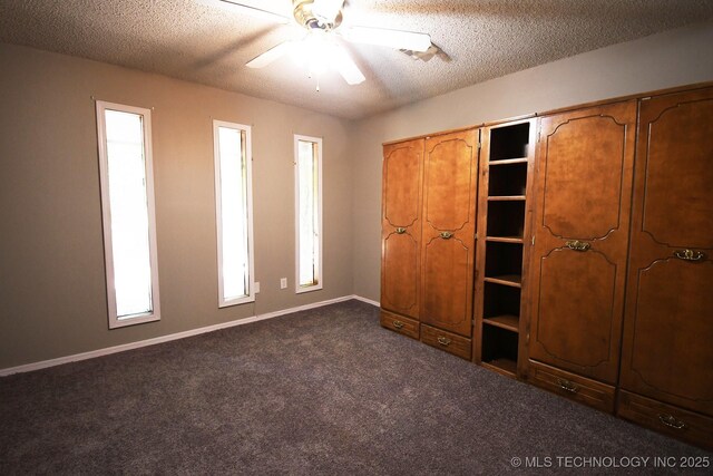 17079 S 125th St, Webbers Falls, OK 74470 - unfurnished bedroom with dark carpet, a textured ceiling, baseboards, and ceiling fan