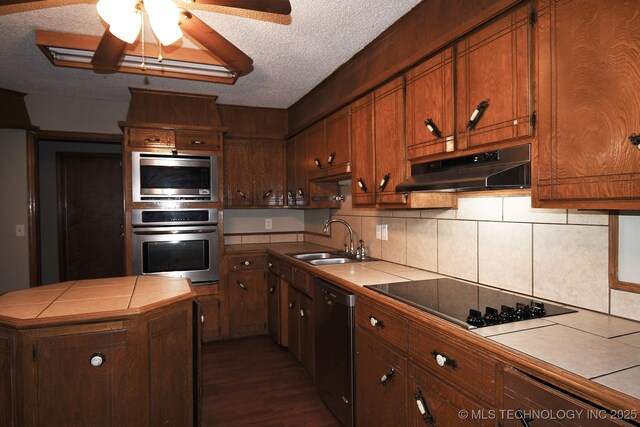 17079 S 125th St, Webbers Falls, OK 74470 - kitchen with tile counters, stainless steel appliances, under cabinet range hood, a sink, and dark wood-style floors