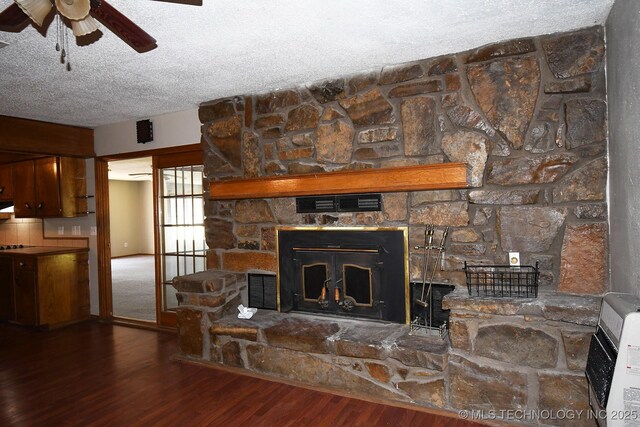 17079 S 125th St, Webbers Falls, OK 74470 - detailed view of a ceiling fan, wood finished floors, a stone fireplace, a textured ceiling, and heating unit