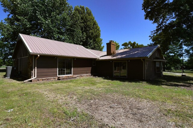 17079 S 125th St, Webbers Falls, OK 74470 - rear view of property featuring a chimney, a lawn, cooling unit, and metal roof