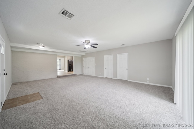 128 Suburban Ln, Inola, OK 74036 - unfurnished room featuring carpet flooring, ceiling fan, baseboards, and brick wall