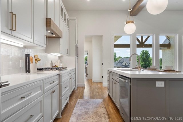 2338 E 134th St S, Bixby, OK 74008 - kitchen with stainless steel appliances, exhaust hood, decorative backsplash, light countertops, and light wood finished floors
