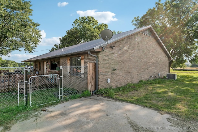 896 SW 1060th, Wilburton, OK 74578 - view of side of property featuring a gate, brick siding, and central AC unit