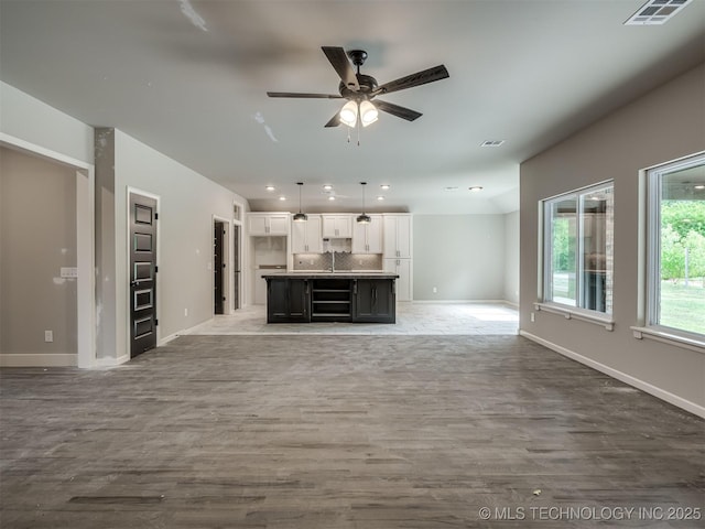 13155 S 105th E Ave, Bixby, OK 74008 - unfurnished living room featuring wood finished floors, a ceiling fan, baseboards, recessed lighting, and a sink