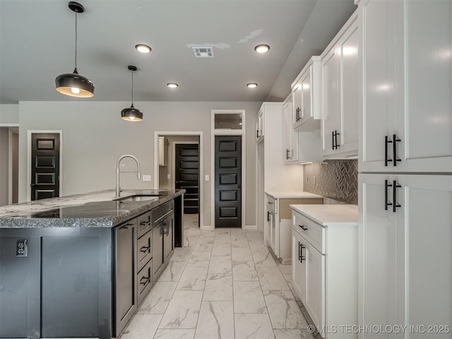 13155 S 105th E Ave, Bixby, OK 74008 - kitchen featuring a sink, light marble finish floors, recessed lighting, dark stone counters, and a center island with sink