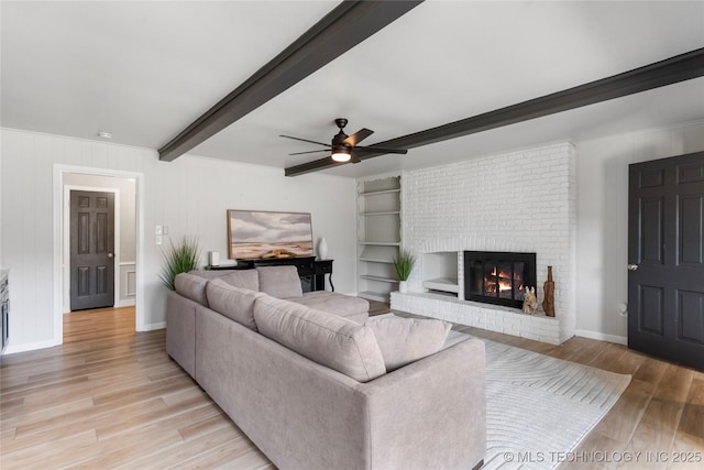 7532 E 55th Pl, Tulsa, OK 74145 - living area with light wood-style floors, beam ceiling, a ceiling fan, a fireplace, and baseboards