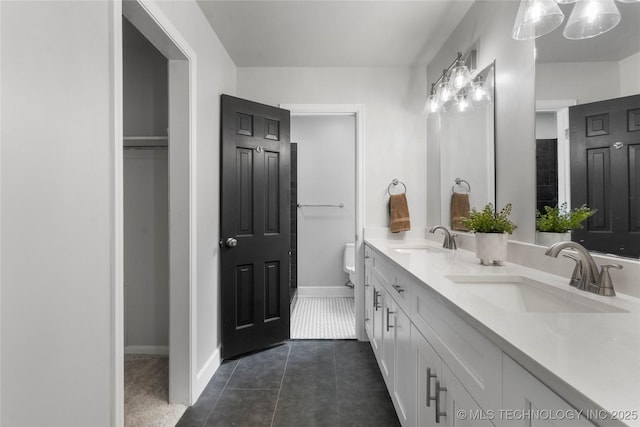 7532 E 55th Pl, Tulsa, OK 74145 - full bathroom with double vanity, tile patterned floors, toilet, baseboards, and a closet
