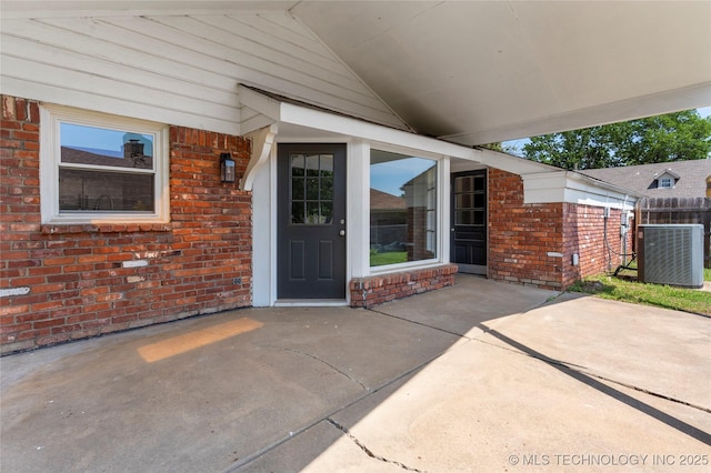 7532 E 55th Pl, Tulsa, OK 74145 - doorway to property featuring central air condition unit, brick siding, and a patio