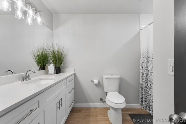 7532 E 55th Pl, Tulsa, OK 74145 - full bath with vanity, toilet, wood finished floors, baseboards, and a shower with shower curtain