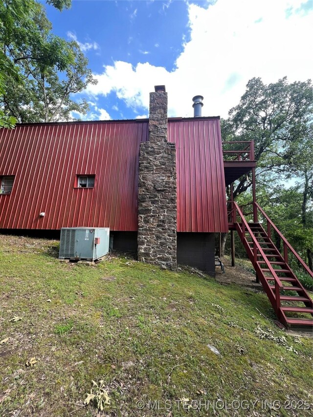 95398 S 4556, Vian, OK 74962 - view of home's exterior with stairs, a chimney, a metal roof, and a lawn