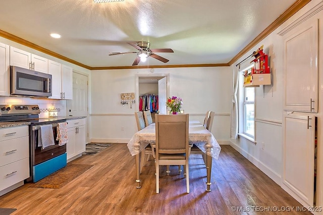 7008 S Hwy 28, Chelsea, OK 74016 - dining room with crown molding, baseboards, wood finished floors, and a ceiling fan