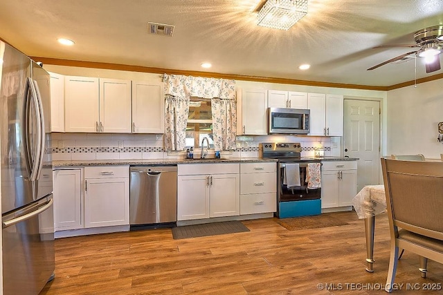 7008 S Hwy 28, Chelsea, OK 74016 - kitchen featuring stainless steel appliances, a sink, a ceiling fan, tasteful backsplash, and crown molding