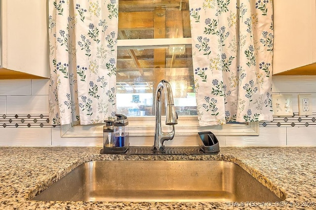 7008 S Hwy 28, Chelsea, OK 74016 - kitchen view of a sink, decorative backsplash, stone countertops, and white cabinets