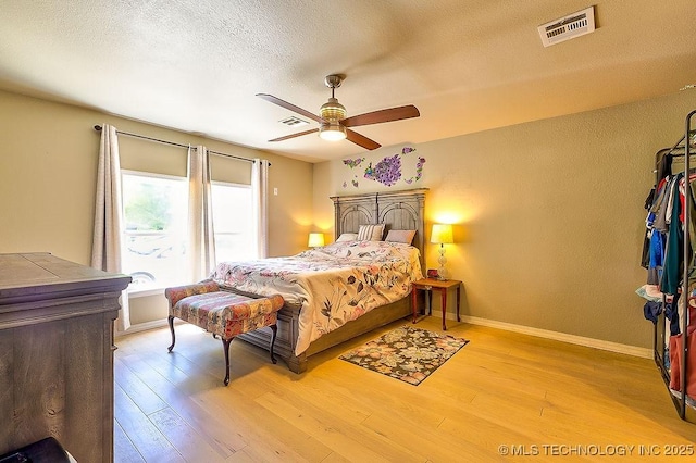 7008 S Hwy 28, Chelsea, OK 74016 - bedroom featuring light wood finished floors, baseboards, a textured ceiling, and ceiling fan