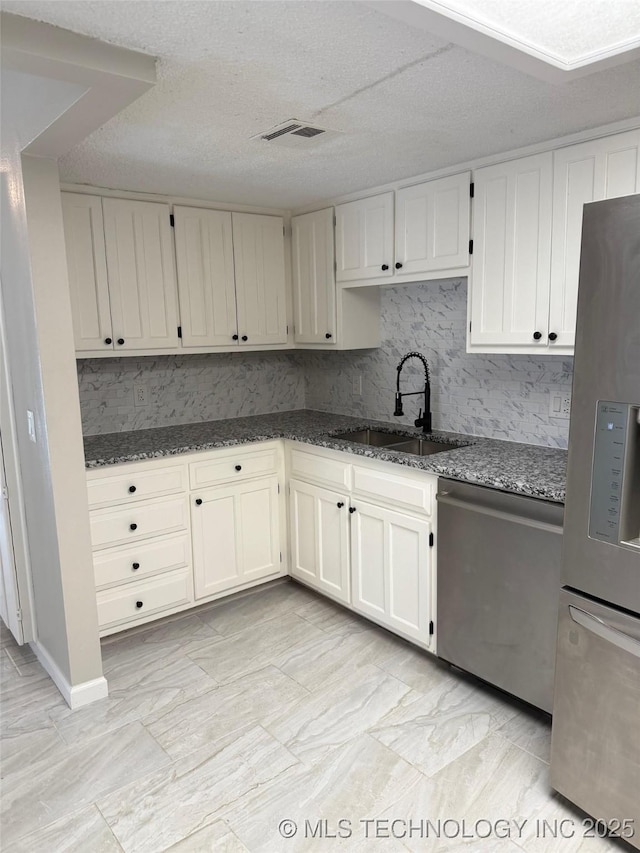2800 E Seattle St, Broken Arrow, OK 74014 - kitchen with appliances with stainless steel finishes, a sink, dark stone counters, and white cabinetry