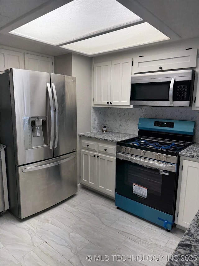 2800 E Seattle St, Broken Arrow, OK 74014 - kitchen with stainless steel appliances, light marble finish floors, light stone counters, and decorative backsplash