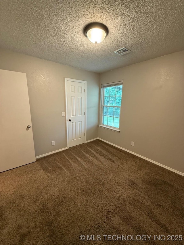2800 E Seattle St, Broken Arrow, OK 74014 - spare room featuring dark colored carpet, a textured ceiling, and baseboards