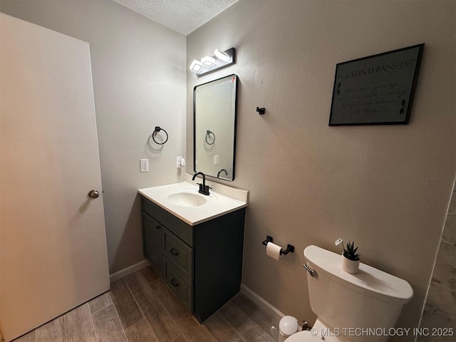 2800 E Seattle St, Broken Arrow, OK 74014 - bathroom with vanity, a textured ceiling, toilet, wood finished floors, and baseboards