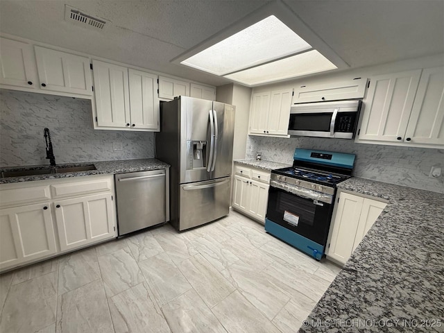 2800 E Seattle St, Broken Arrow, OK 74014 - kitchen with appliances with stainless steel finishes, a sink, dark stone counters, and decorative backsplash