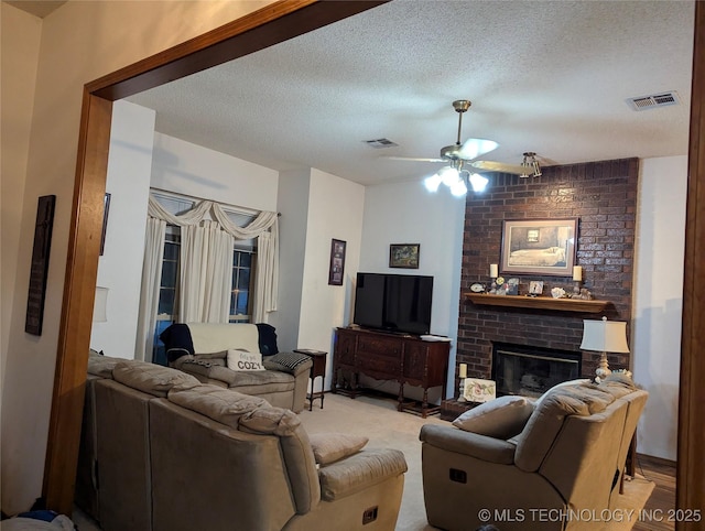 11309 S 107th E Ave, Bixby, OK 74008 - living room featuring ceiling fan, a textured ceiling, and a fireplace