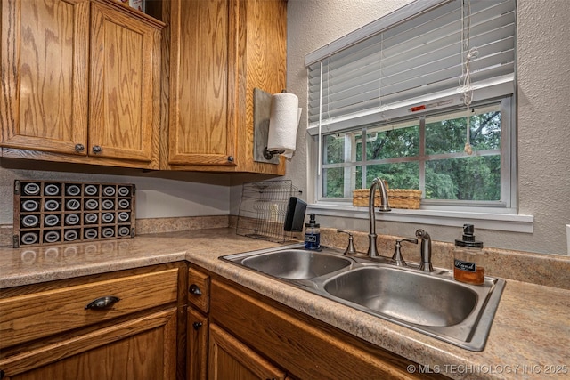 1319 SE 3rd St, Antlers, OK 74523 - kitchen featuring a textured wall, a sink, brown cabinets, and light countertops