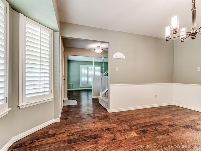 406 Sequoyah Trl, Norman, OK 73071 - empty room featuring dark wood-style flooring, a chandelier, stairway, and baseboards