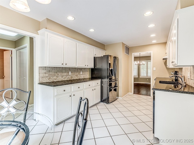 406 Sequoyah Trl, Norman, OK 73071 - kitchen with black fridge with ice dispenser, a sink, white cabinetry, decorative backsplash, and a chandelier