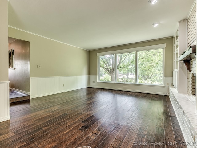 406 Sequoyah Trl, Norman, OK 73071 - unfurnished living room featuring dark wood-style floors, a brick fireplace, wainscoting, and ornamental molding