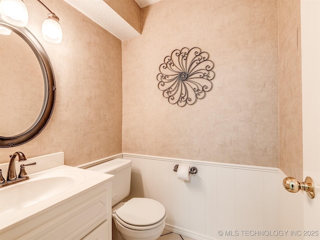 406 Sequoyah Trl, Norman, OK 73071 - bathroom with wainscoting, toilet, vanity, and wallpapered walls