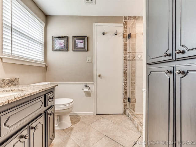 406 Sequoyah Trl, Norman, OK 73071 - bathroom featuring a shower stall, toilet, vanity, a wainscoted wall, and tile patterned flooring