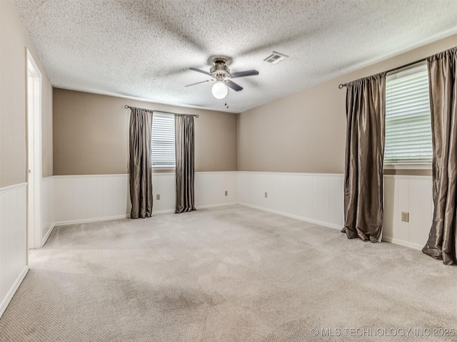 406 Sequoyah Trl, Norman, OK 73071 - empty room with ceiling fan, wainscoting, carpet, and a textured ceiling
