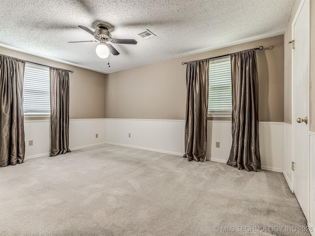 406 Sequoyah Trl, Norman, OK 73071 - empty room featuring a ceiling fan, carpet floors, wainscoting, and a textured ceiling