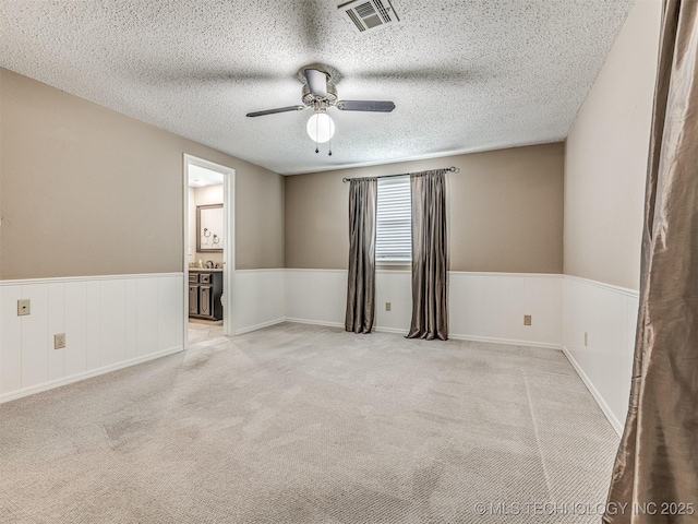 406 Sequoyah Trl, Norman, OK 73071 - unfurnished room with ceiling fan, carpet floors, a wainscoted wall, and a textured ceiling