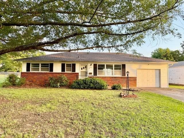 1714 E 11th St, Okmulgee, OK 74447 - ranch-style house featuring brick siding, a garage, driveway, and a front lawn