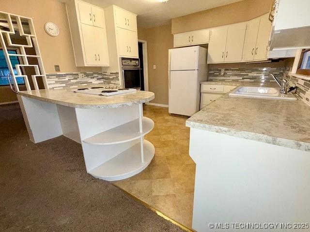 1714 E 11th St, Okmulgee, OK 74447 - kitchen with white appliances, open shelves, a peninsula, backsplash, and light countertops