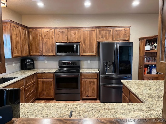 17 Zachary Taylor, Durant, OK 74701 - kitchen featuring electric stove, black fridge, decorative backsplash, recessed lighting, and light stone countertops