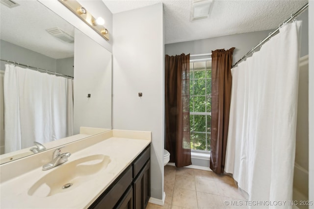 9306 S 94th E Ave, Tulsa, OK 74133 - full bathroom with vanity, toilet, healthy amount of natural light, a textured ceiling, and baseboards