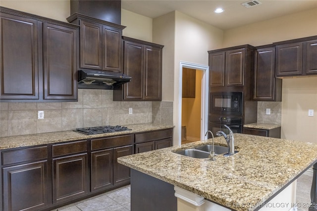 1425 Switchgrass, Edmond, OK 73013 - kitchen with a sink, black appliances, under cabinet range hood, light stone counters, and backsplash