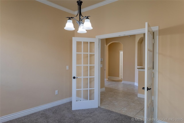 1425 Switchgrass, Edmond, OK 73013 - empty room featuring arched walkways, ornamental molding, light tile patterned flooring, a chandelier, and baseboards