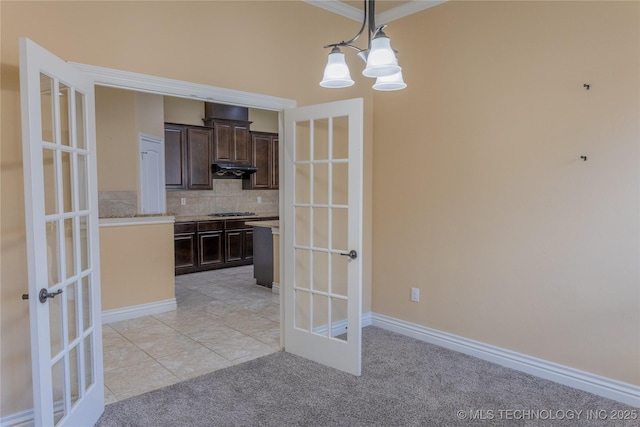 1425 Switchgrass, Edmond, OK 73013 - kitchen with french doors, dark brown cabinetry, tasteful backsplash, light colored carpet, and decorative light fixtures