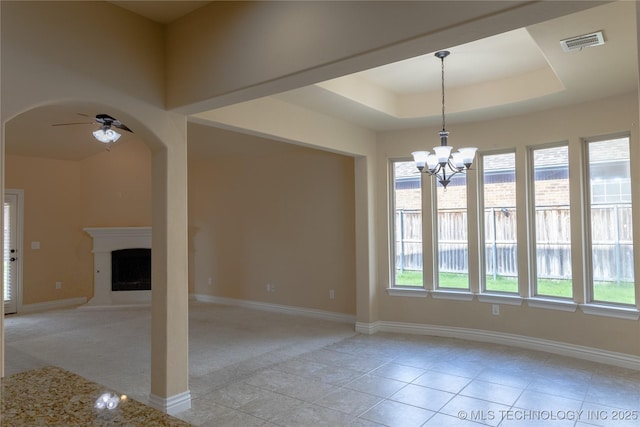 1425 Switchgrass, Edmond, OK 73013 - spare room with a ceiling fan, arched walkways, a chandelier, a fireplace with raised hearth, and baseboards