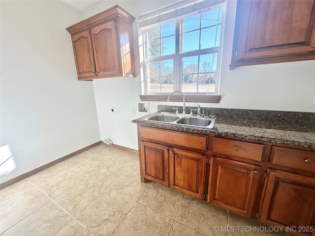 2013 State Highway 9a, Eufaula, OK 74432 - kitchen featuring a sink, light tile patterned flooring, baseboards, dark stone counters, and brown cabinets
