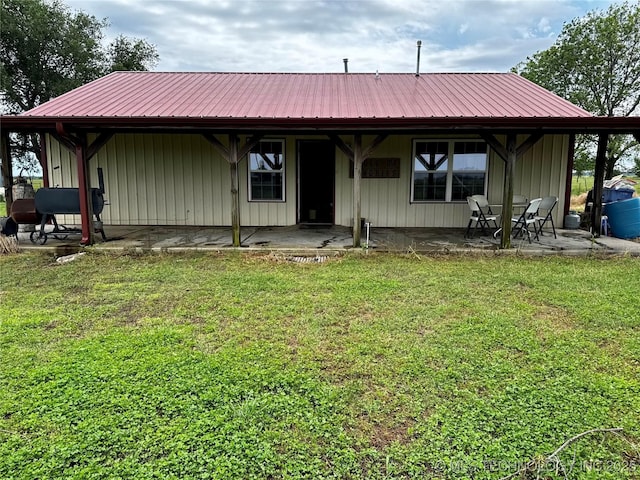 26230 Ash Rd, Boynton, OK 74422 - rear view of house with a patio area, a lawn, and metal roof