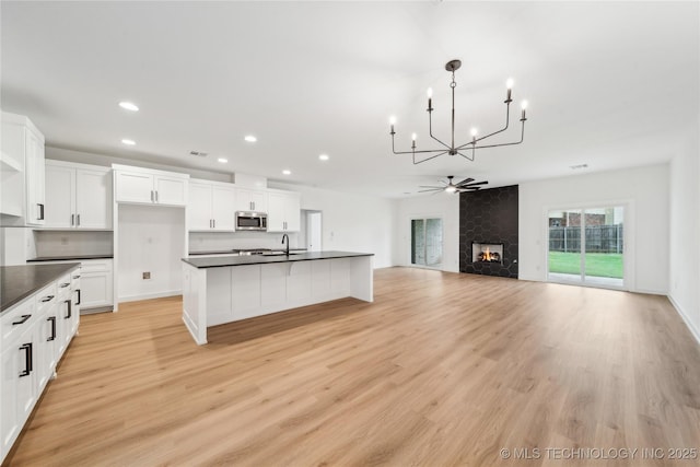 2504 W Birmingham St, Broken Arrow, OK 74011 - kitchen featuring stainless steel microwave, dark countertops, a chandelier, recessed lighting, and white cabinets