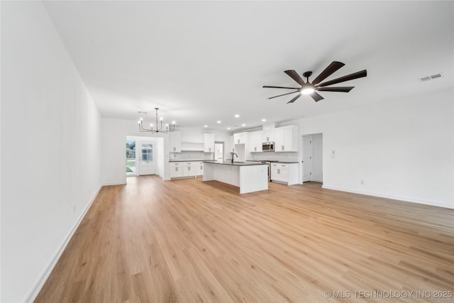 2504 W Birmingham St, Broken Arrow, OK 74011 - unfurnished living room featuring a chandelier, a sink, ceiling fan, baseboards, and light wood-type flooring